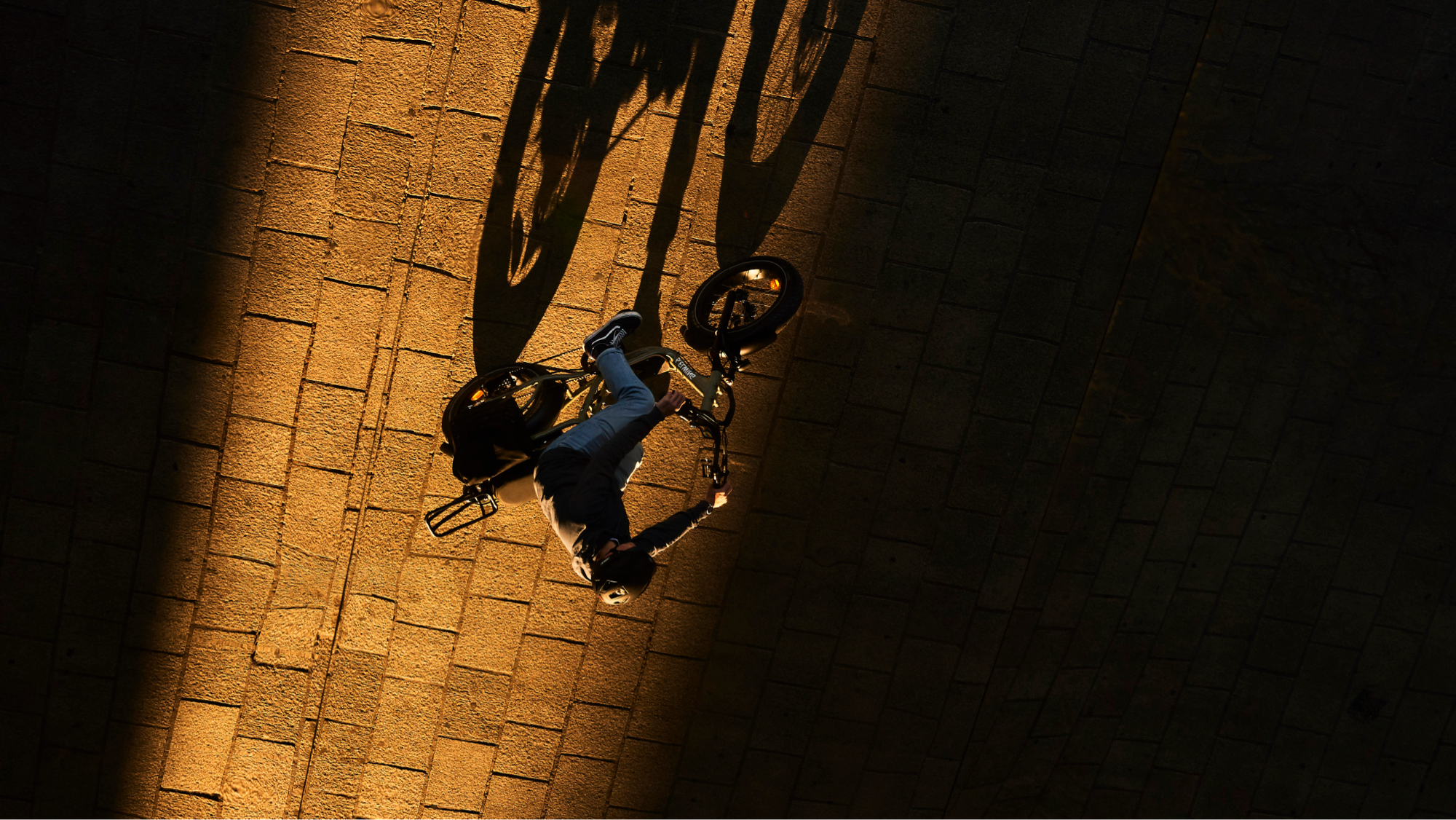 Homme sur un vélo Yuvy 2 vu de haut entre ombre et lumière